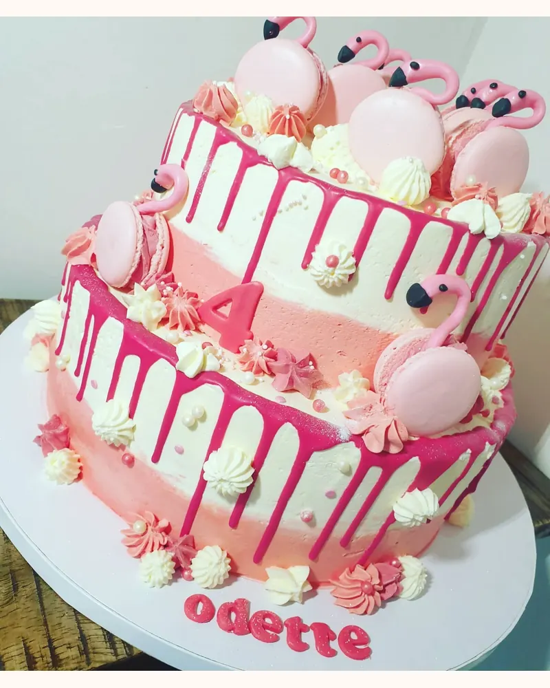Roze drip cake met twee lagen en flamingo's