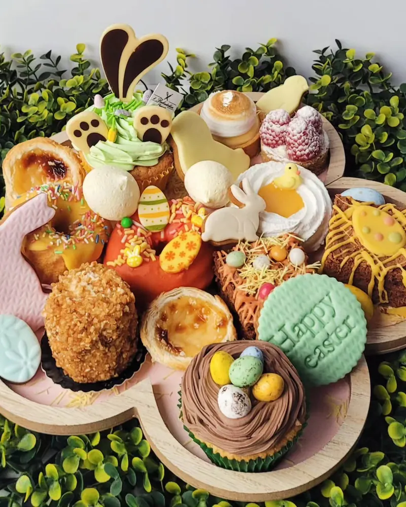 Paasschaal met mini-desserts: cupcake met eitjes, pasteis de nata, koekjes en taartjes