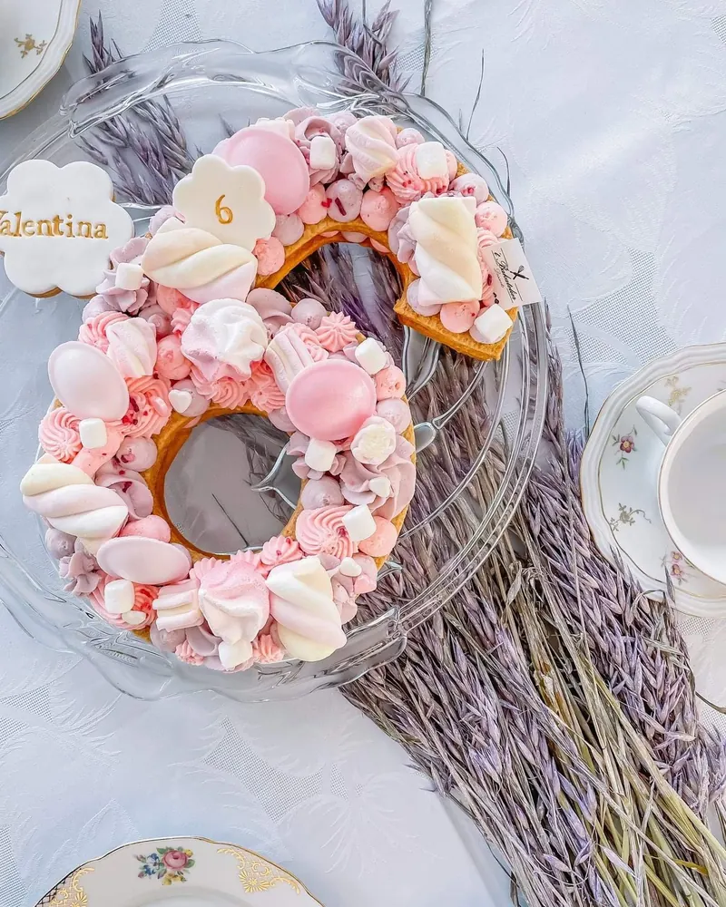 Cijfertaart 6 met meringues en roze toefjes naast lavendel