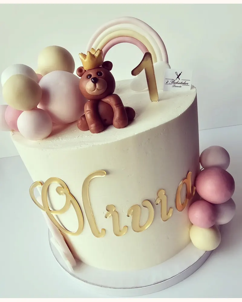 Taart met een teddybeer, regenboog en gouden naamtopper