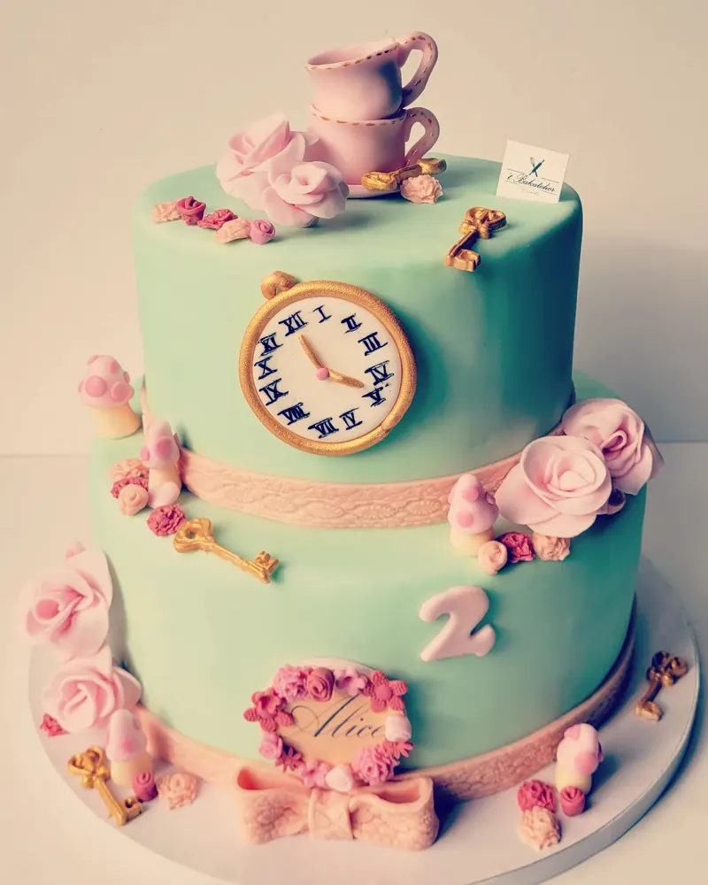 Taart met twee lagen in mint en roze met theekopje en klok